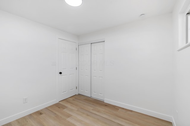 unfurnished bedroom featuring light hardwood / wood-style flooring and a closet