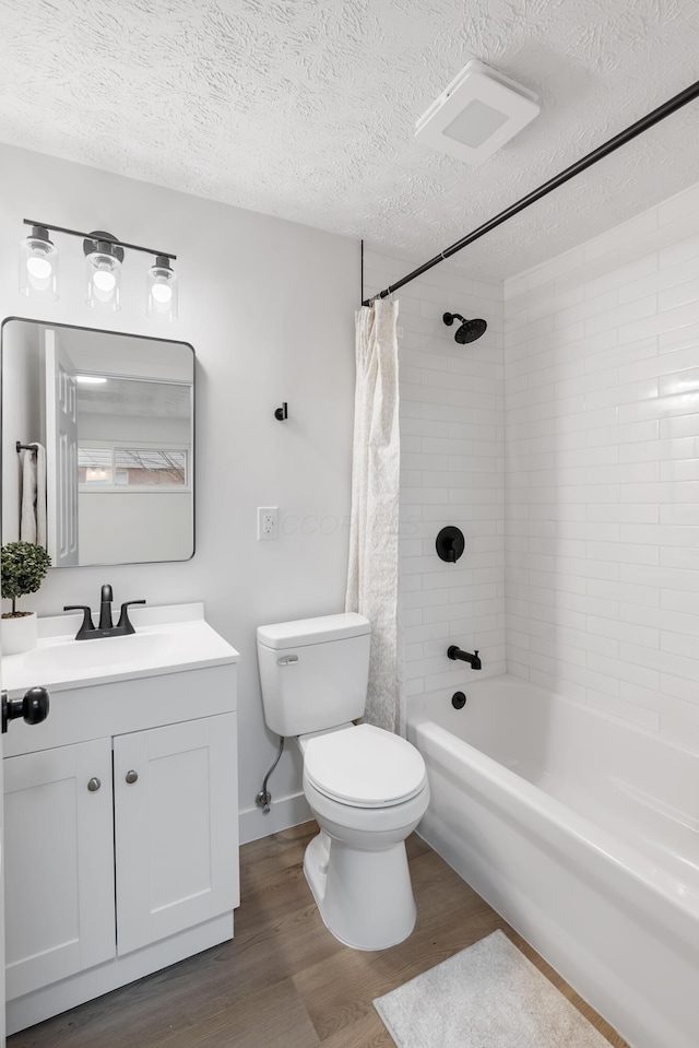 full bathroom with vanity, hardwood / wood-style floors, a textured ceiling, and toilet