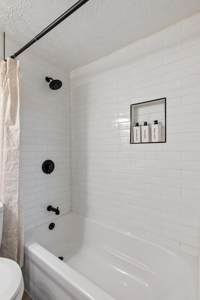 bathroom with shower / bathtub combination with curtain, a textured ceiling, and toilet