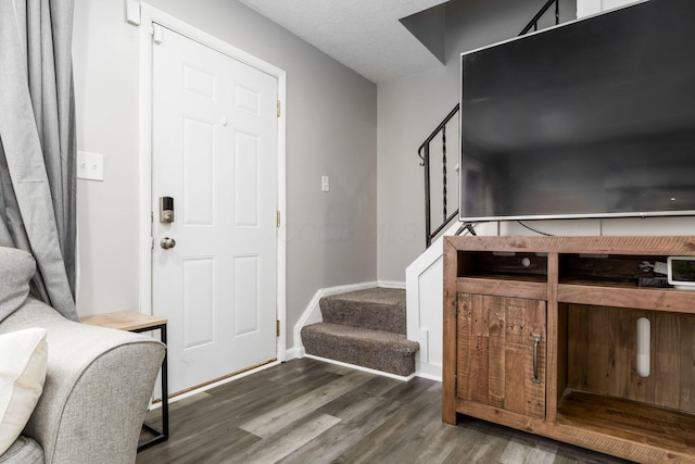 foyer entrance featuring dark hardwood / wood-style flooring and a textured ceiling