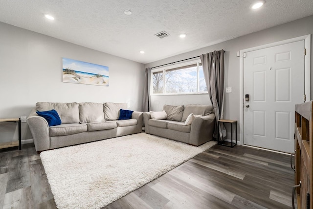 living room featuring dark hardwood / wood-style flooring and a textured ceiling