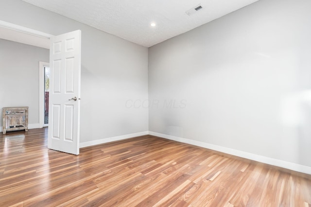 empty room featuring hardwood / wood-style floors and a textured ceiling