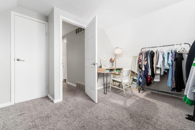 walk in closet with vaulted ceiling and carpet