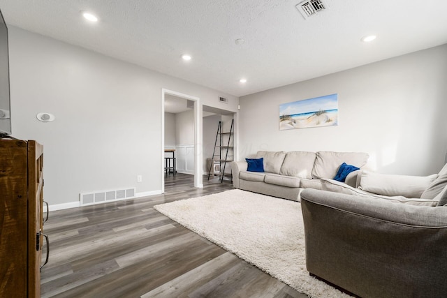 living room with dark hardwood / wood-style floors and a textured ceiling