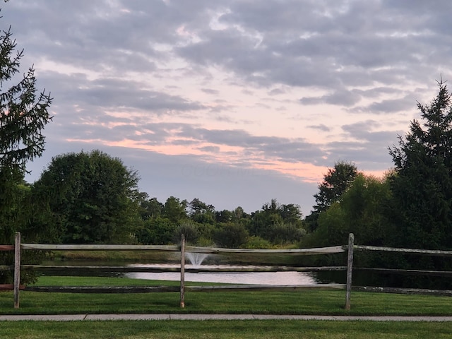 view of property's community featuring a lawn and a water view