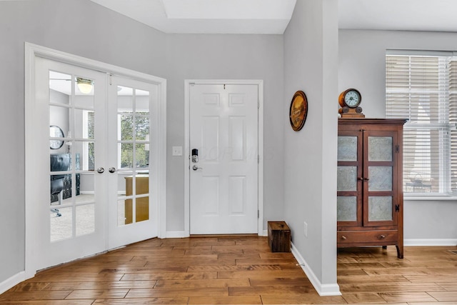 foyer entrance with french doors and light hardwood / wood-style flooring