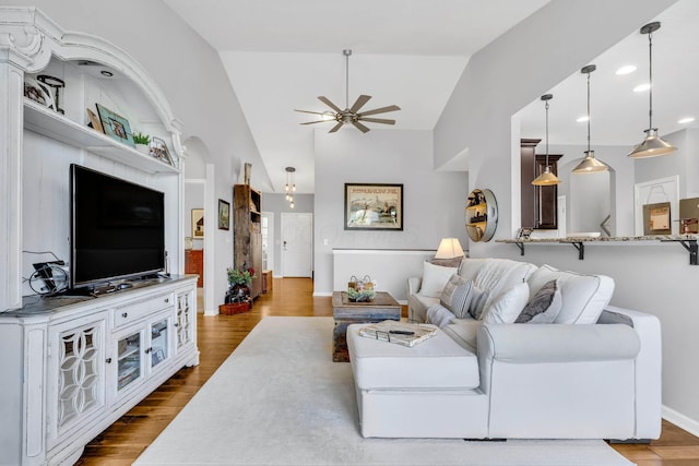 living room featuring hardwood / wood-style flooring, vaulted ceiling, and ceiling fan