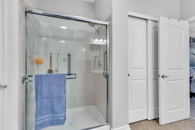 bathroom with tile patterned flooring and a shower with shower door