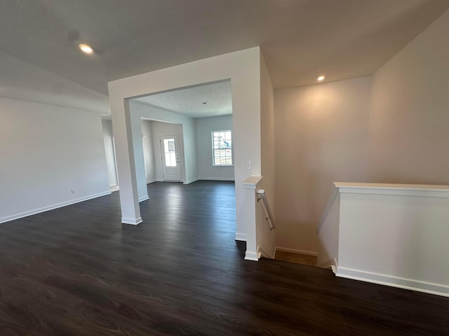 spare room featuring dark wood finished floors, baseboards, and recessed lighting