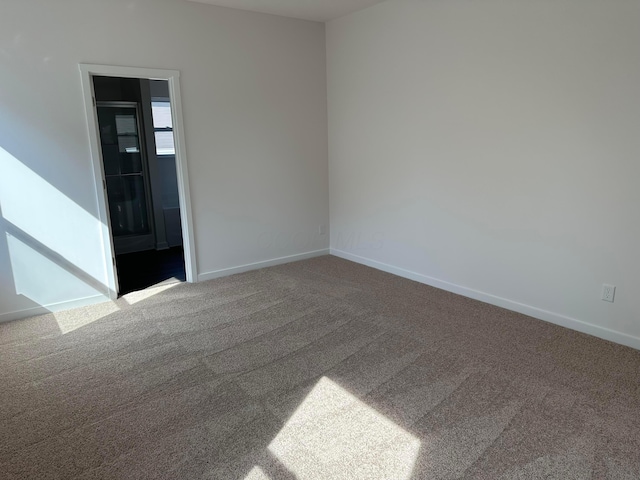 spare room with carpet and baseboards