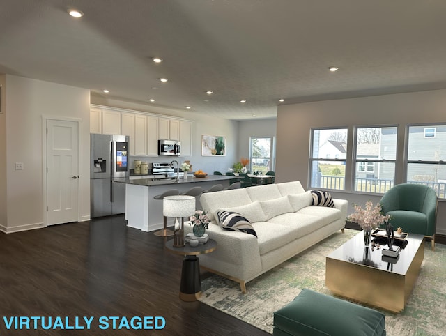 living room featuring dark wood-type flooring, baseboards, and recessed lighting