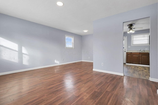 spare room featuring dark wood-type flooring and ceiling fan