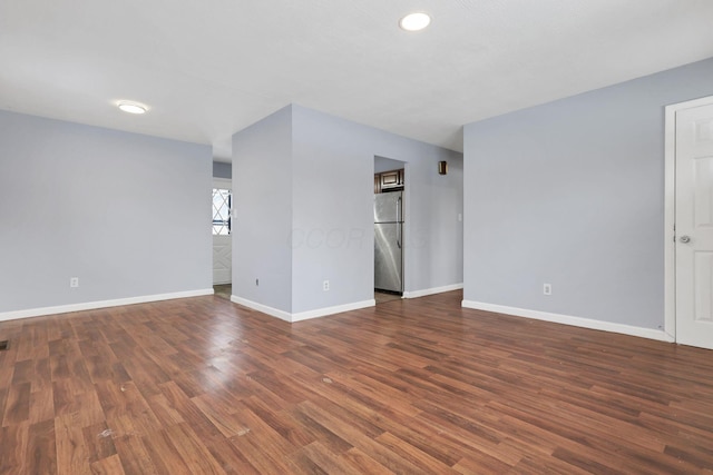 unfurnished room with dark hardwood / wood-style flooring