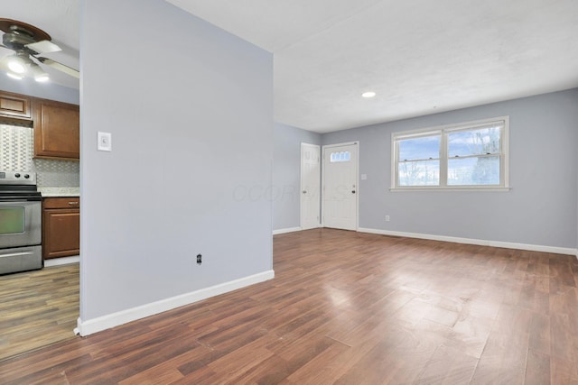 unfurnished living room with dark hardwood / wood-style floors and ceiling fan