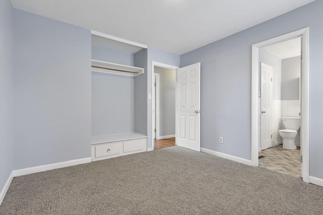 unfurnished bedroom with light carpet, ensuite bath, and tile walls