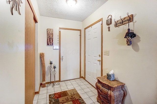 doorway to outside featuring light tile patterned floors and a textured ceiling