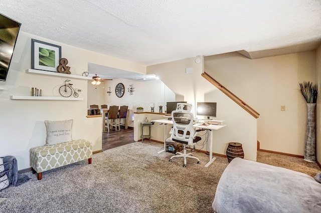 carpeted office with ceiling fan and a textured ceiling