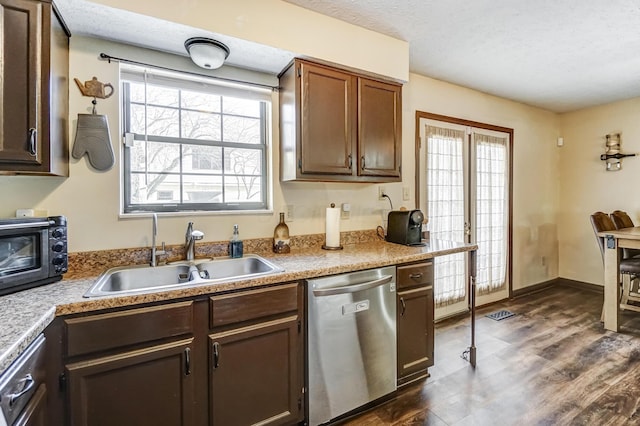 kitchen featuring sink, dark wood-type flooring, dishwasher, dark brown cabinetry, and a textured ceiling