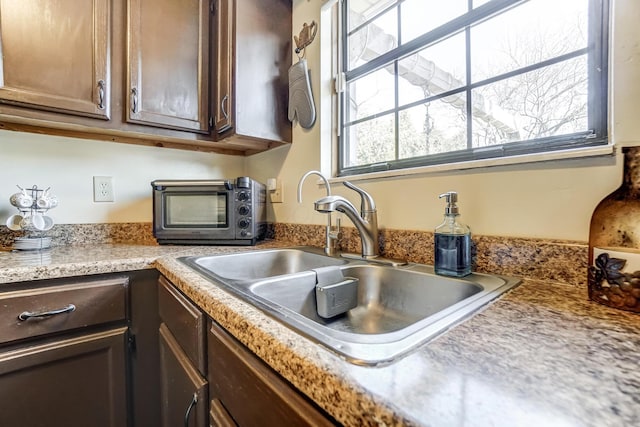 kitchen featuring dark brown cabinets and sink