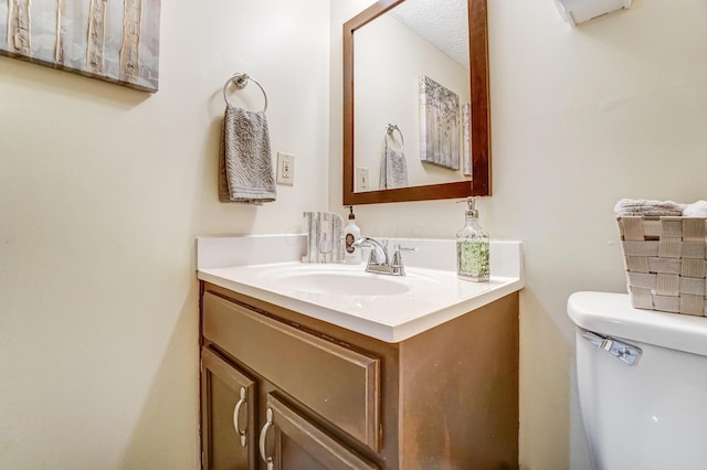 bathroom with vanity, a textured ceiling, and toilet