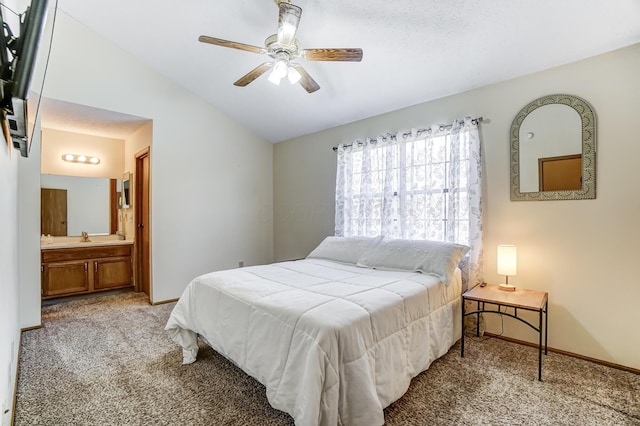 bedroom with ensuite bath, vaulted ceiling, light colored carpet, and ceiling fan