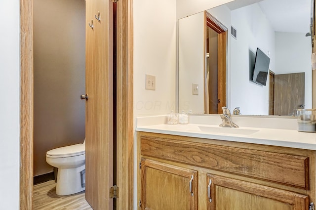 bathroom with vanity, hardwood / wood-style floors, and toilet