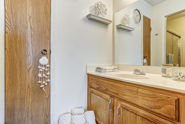 bathroom featuring walk in shower and vanity