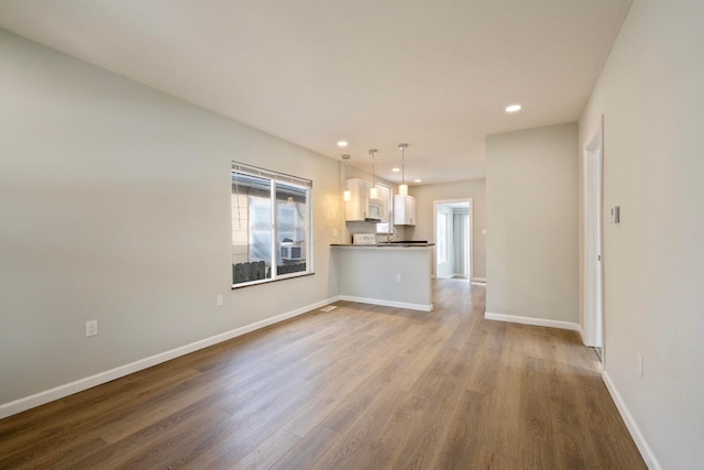 unfurnished living room featuring hardwood / wood-style flooring