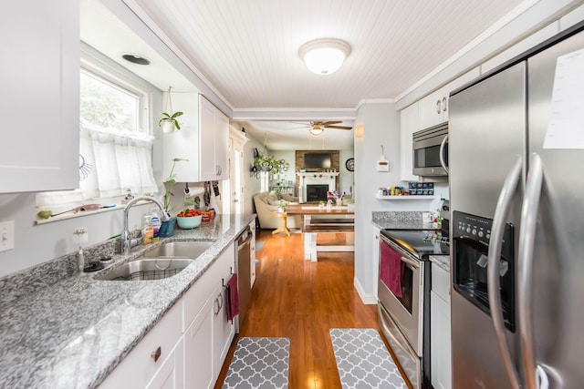 kitchen featuring stainless steel appliances, white cabinetry, wood-type flooring, and sink