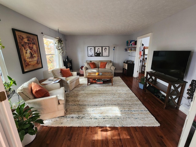 living room with dark hardwood / wood-style flooring and a textured ceiling