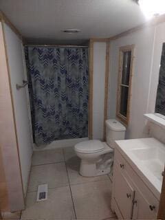 bathroom featuring tile patterned flooring, vanity, a shower with shower curtain, and toilet