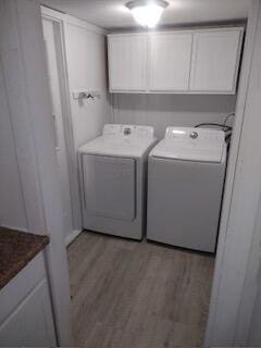 laundry room featuring independent washer and dryer, cabinets, and hardwood / wood-style floors