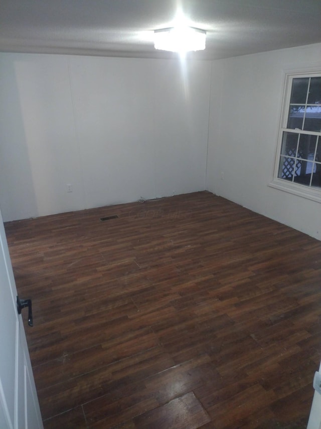 unfurnished room with dark hardwood / wood-style floors