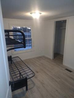 bedroom with hardwood / wood-style flooring and a closet