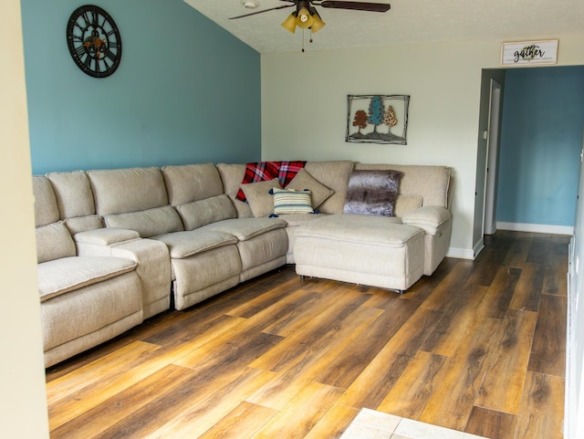 living area with dark wood-style floors, ceiling fan, and baseboards