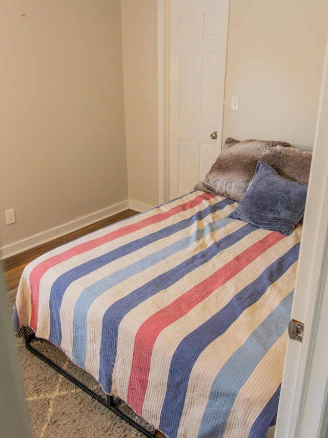 bedroom featuring wood finished floors and baseboards