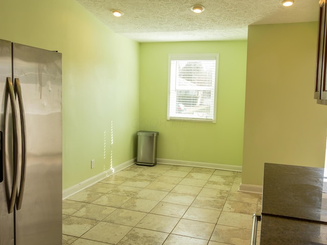 interior space with recessed lighting, a textured ceiling, and baseboards