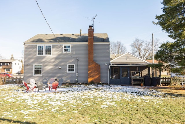 back of house with a patio, an outdoor fire pit, a sunroom, and a lawn