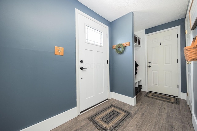 entryway with a textured ceiling and dark hardwood / wood-style flooring