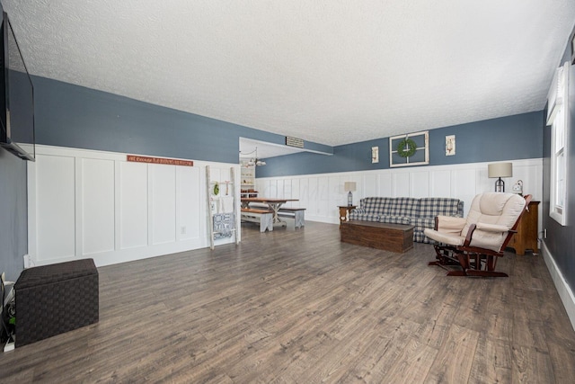 living area featuring dark wood-type flooring and a textured ceiling