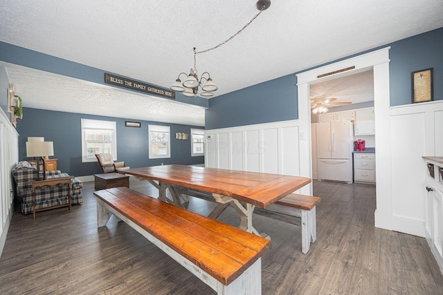 dining area with dark hardwood / wood-style floors, an inviting chandelier, and a textured ceiling