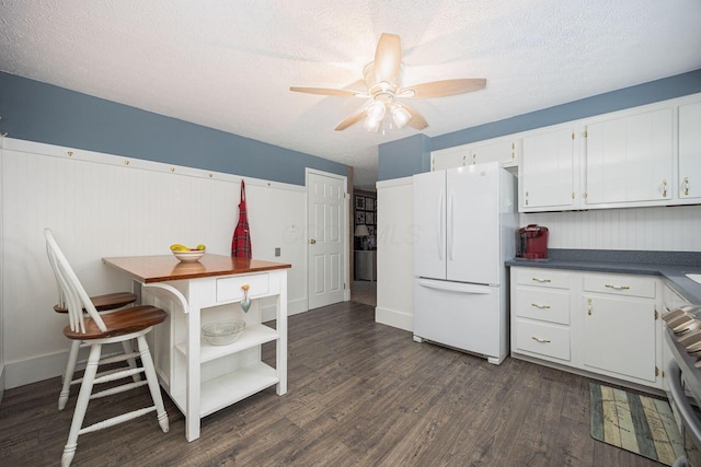 kitchen featuring white refrigerator, white cabinetry, and a textured ceiling