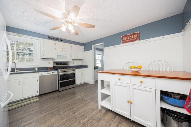 kitchen featuring a textured ceiling, plenty of natural light, white cabinets, and appliances with stainless steel finishes