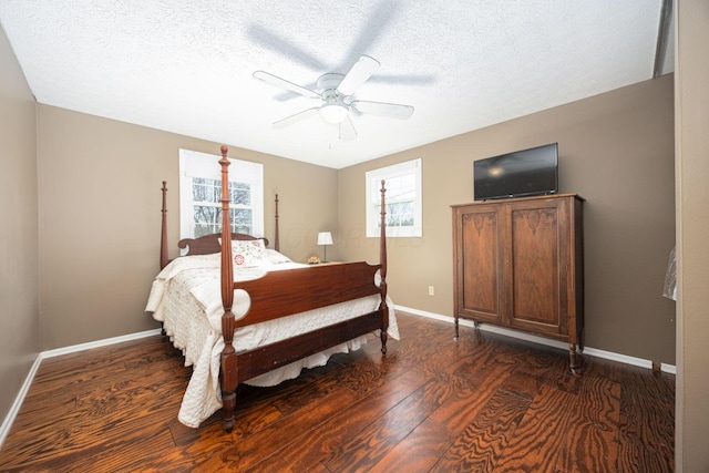 bedroom with multiple windows, ceiling fan, dark wood-type flooring, and a textured ceiling