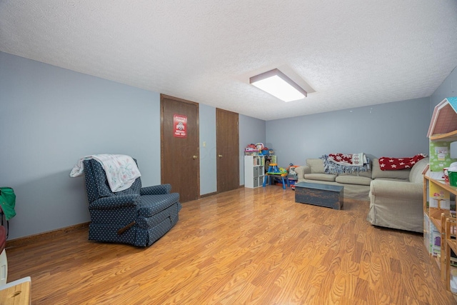 living room with light hardwood / wood-style floors and a textured ceiling