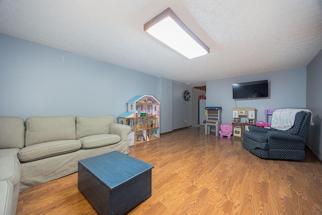 living room featuring wood-type flooring and a textured ceiling