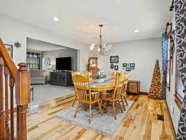 dining room featuring light hardwood / wood-style floors and a chandelier