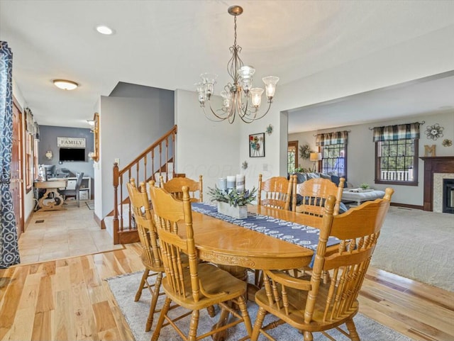 dining area with light wood-type flooring and an inviting chandelier