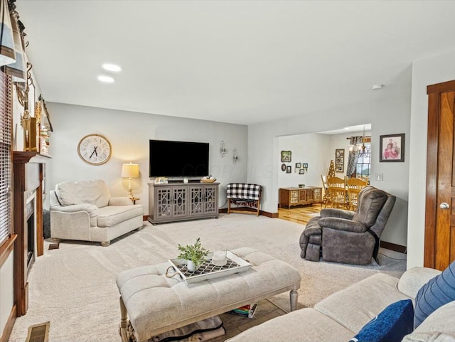 living room featuring carpet floors, an inviting chandelier, and a fireplace