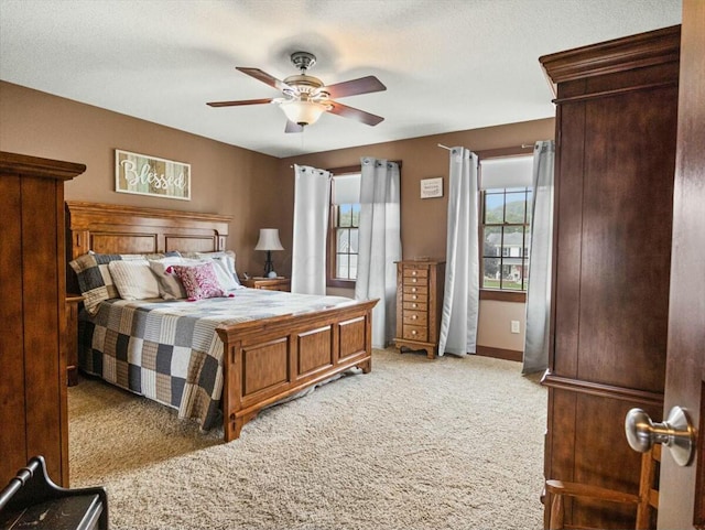 bedroom featuring light carpet, ceiling fan, and a textured ceiling